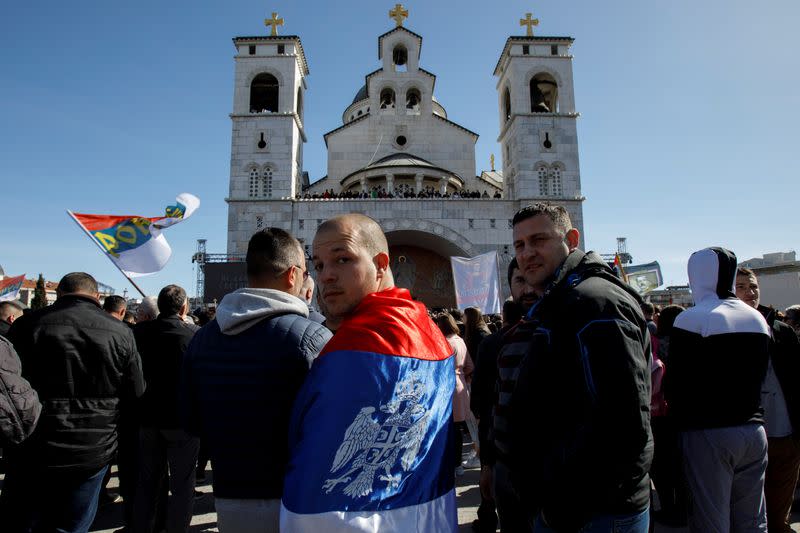 A man wrapped in a Serbian flag reacts before a protest march against a new law on religious freedom and legal rights of religious organizations in Podgorica