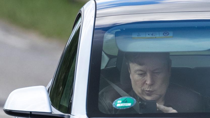 Tesla CEO Elon Musk uses his mobile device as he sits in the car arriving to the construction site for the new plant, the so-called "Giga Factory", of US electric carmaker Tesla in Gruenheide near Berlin, northeastern Germany. - The site still has only provisional construction permits, but Tesla has been authorised by local officials to begin work at its own risk. Tesla is aiming to produce 500,000 electric vehicles a year at the plant, which will also be home to "the largest battery factory in the world", according to group boss Elon Musk. (Photo by Odd ANDERSEN / AFP) (Photo by ODD ANDERSEN/AFP via Getty Images)