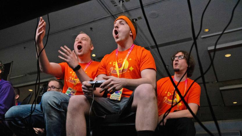 Photo from Summer Games Done Quick 2019, featuring gamers sitting side-by-side, holding controllers and staring intently while appearing to shout or vocalize feelings about the game.