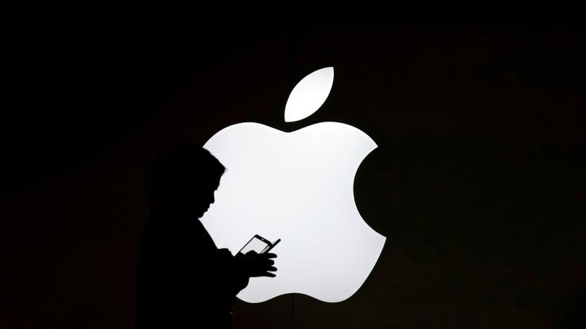 A woman looks at the screen of her mobile phone in front of an Apple logo outside its store in Shanghai, China July 30, 2017. REUTERS/Aly Song     TPX IMAGES OF THE DAY