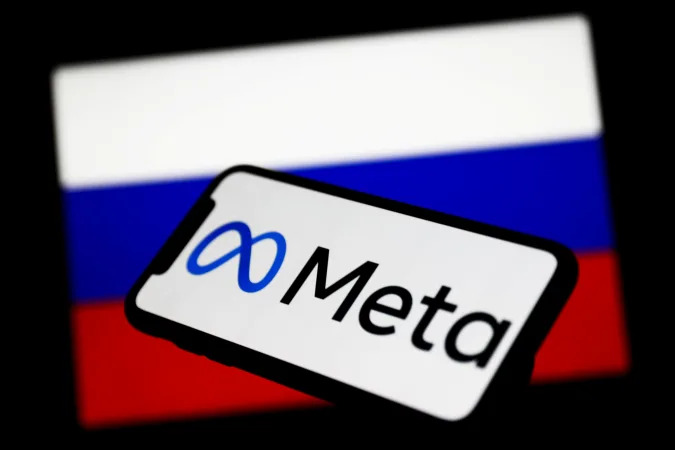 Meta logo displayed on a phone screen and Russian flag displayed on a screen in the background are seen in this illustration photo taken in Krakow, Poland on March 1, 2022. (Photo Illustration by Jakub Porzycki/NurPhoto via Getty Images)