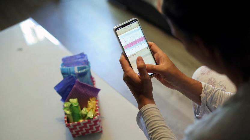 Raquel del Rio, 36, who works in police forces, poses as she observes a period calendar tracker app on her mobile phone at her home in Madrid, Spain, May 16, 2022. Picture taken May 16, 2022. REUTERS/Isabel Infantes