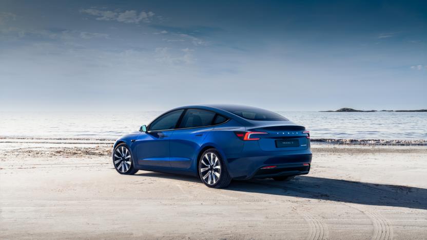 A blue sedan on the beach.