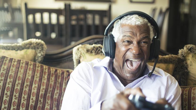 A senior black man having fun playing video games  with a headset to communicate with his team