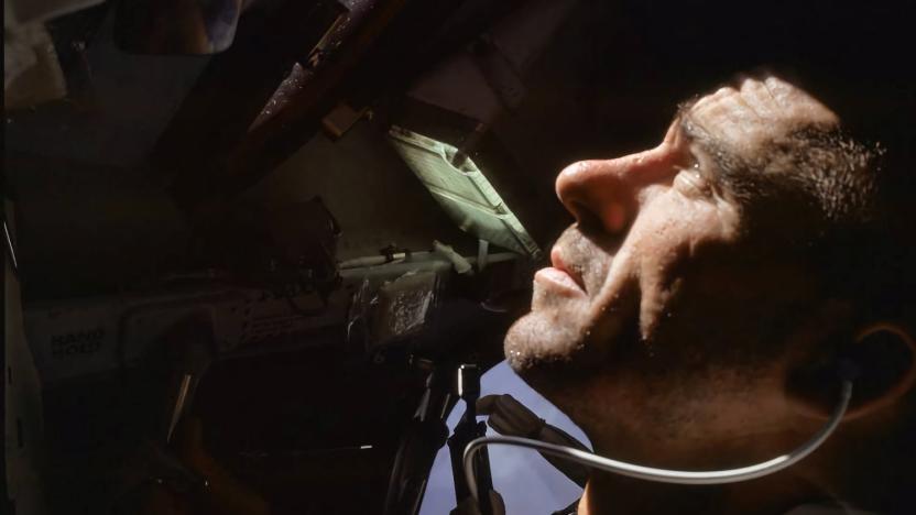 Archival photo of Walter Cunningham looking outward from a capsule into space.