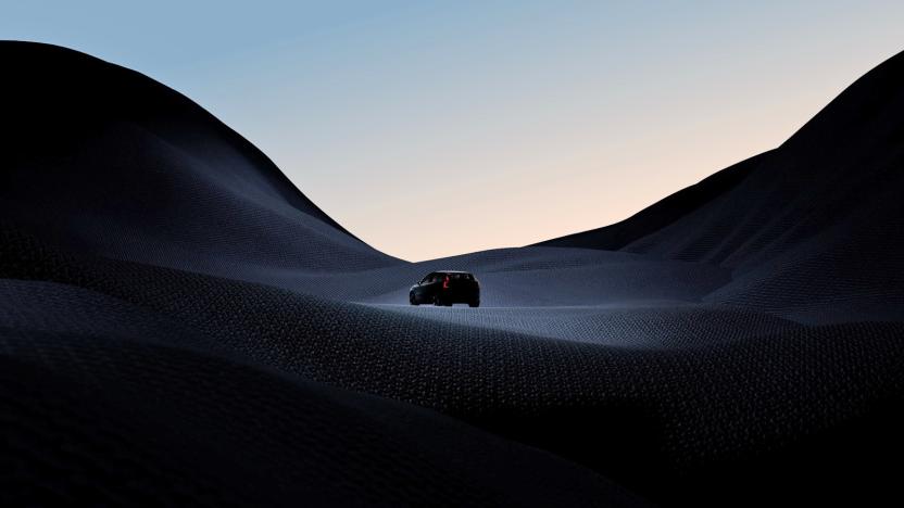 A teaser photo for the Volvo EX30 small SUV showing the silhouette of a small vehicle driving across a dark hilly terrain.