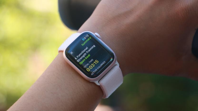 The Apple Watch Series 9 on a person's wrist, with the hand holding a black water bottle in the background. The screen shows the summary of a Functional Strength Training workout.