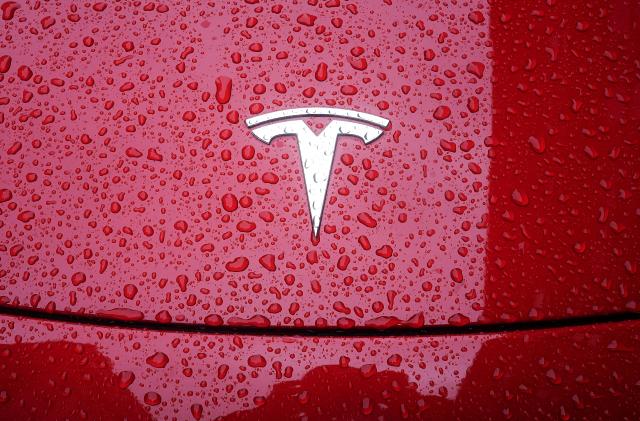 A Tesla logo is pictured on a car in the rain in the Manhattan borough of New York City, New York, U.S., May 5, 2021. REUTERS/Carlo Allegri