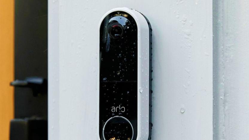 Arlo's wireless video doorbell, fixed to a surface and covered in raindrops.