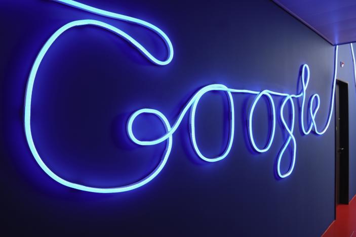 A hallway decorated with an illuminated Google logo.                                    