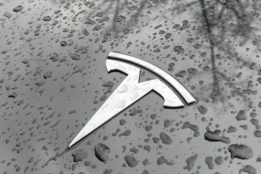 Raindrops are seen next to the Tesla logo on the bonnet of a Tesla electric car in Berlin's Kreuzberg district on January 8, 2023. - Tesla has delivered 1.31 million electric vehicles in 2022 -- a record for the US automaker and a 40 percent jump from a year before, but still short of its own and Wall Street's expectations. (Photo by David GANNON / AFP) (Photo by DAVID GANNON/AFP via Getty Images)