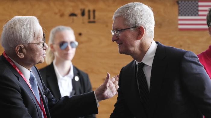 Taiwan Semiconductor Manufacturing Company founder Morris Chang, left, shakes hands with Apple CEO Tim Cook, right, at the TSMC facility under construction in Phoenix, Tuesday, Dec. 6, 2022. (AP Photo/Ross D. Franklin)