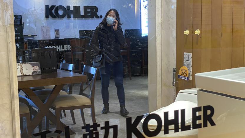 A woman wearing a face mask to help curb the spread of the coronavirus talks on her phone inside a Kohler shop in Beijing, Tuesday, March 16, 2021. Chinese state TV has criticized bathroom fixtures brand Kohler and automaker BMW for using facial recognition to identify customers in a possible violation of privacy rules that took effect this year. (AP Photo/Andy Wong)