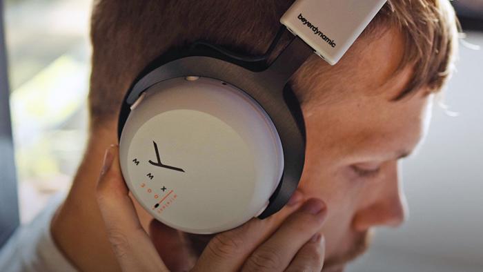 A guy seen in profile wearing MMX 200 over-the-ear headphones while he gazes towards the ground. 