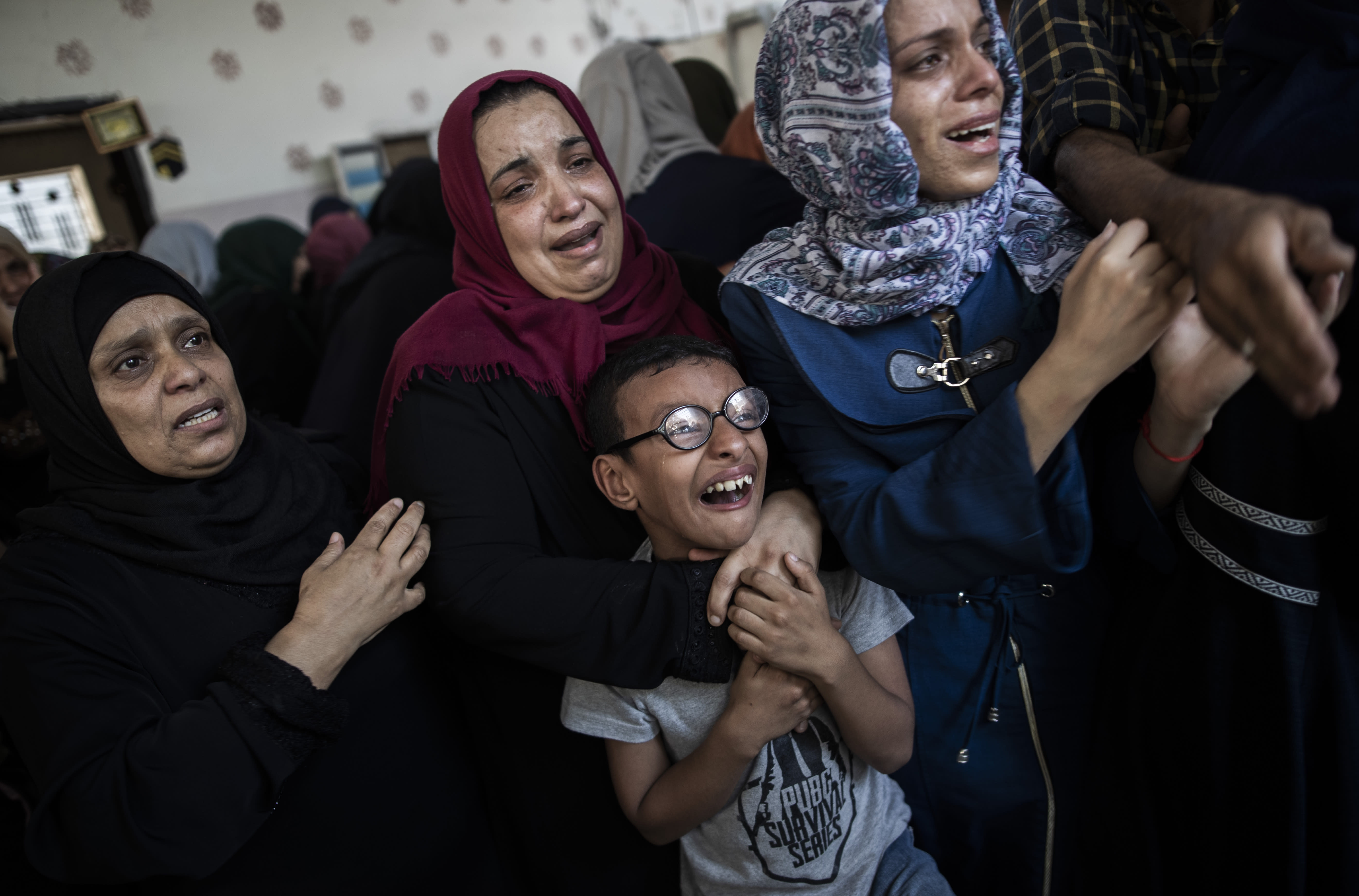 Relatives mourn the death of Palestinian Hamas militant, Mohammad Abu Namous, 27, in the family home during his funeral in the Jabaliya refugee camp, northern Gaza Strip, Sunday, Aug. 18, 2019. Gaza's Health Ministry said Israeli troops killed three Palestinians and severely wounded a fourth near the heavily guarded perimeter fence. The Israeli military said Sunday that a helicopter and a tank fired at a group of armed suspects near the fence overnight. (AP Photo/Khalil Hamra)