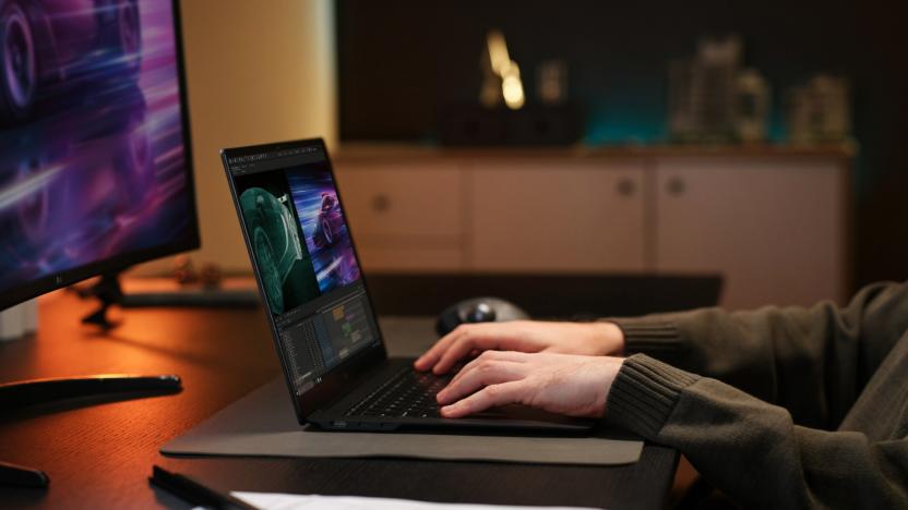 A pair of hands using a laptop on a desk. 