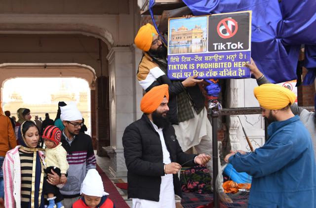 Sikh volunteers hangs a board reading 'Tiktok is prohibited here' at the Golden Temple in Amritsar on February 10, 2020. (Photo by NARINDER NANU / AFP) (Photo by NARINDER NANU/AFP via Getty Images)