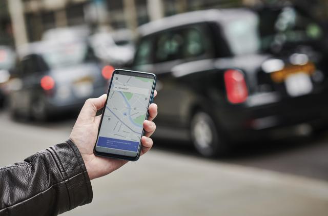 LONDON, UNITED KINGDOM - JUNE 4: Detail of a man holding up an Honor 20 Pro smartphone with the Uber transport app visible on screen, while taxis queue in the background, on June 4, 2019. (Photo by Olly Curtis/Future via Getty Images)