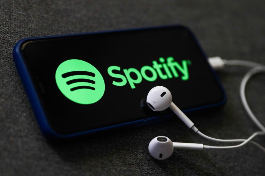 Spotify logo displayed on a phone screen and headphones are seen in this illustration photo taken in Poland on October 18, 2020. 
 (Photo Illustration by Jakub Porzycki/NurPhoto via Getty Images)