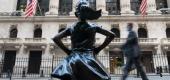 Getty Images - People walk past the New York Stock Exchange and the "Fearless Girl" statue. (Getty Images)