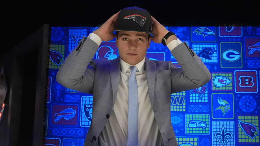 Associated Press - North Carolina quarterback Drake Maye puts on a hat after being chosen by the New England Patriots with the third overall pick during the first round of the NFL football draft, Thursday, April 25, 2024, in Detroit. (AP Photo/Jeff Roberson)