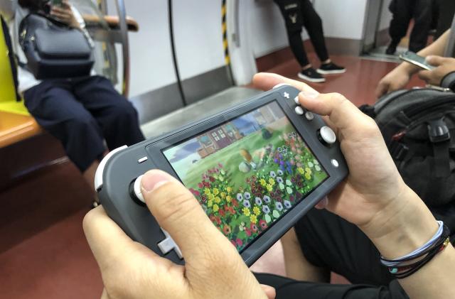 BEIJING, CHINA - JUNE 14: A passenger uses a Nintendo Switch to play video game 'Animal Crossing: New Horizons' on a subway train of Beijing Subway Line 1 on June 14, 2020 in Beijing, China. (Photo by VCG/VCG via Getty Images)