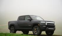 A dark gray truck parked on the grass.