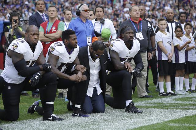 Baltimore Ravens outside linebacker Terrell Suggs, from left, Mike Wallace, former player Ray Lewis and inside linebacker C.J. Mosley kneel down during the playing of the U.S. national anthem. (AP)