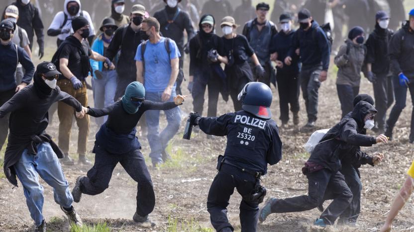 GRUENHEIDE, GERMANY - MAY 10: Police confront environmental activists in a forest near the Tesla Gigafactory electric car factory on May 10, 2024 near Gruenheide, Germany. Activists have come from across Germany to demand a stop to plans by Tesla to expand the factory, which would involve cutting down at least 50 hectares of trees. Some locals also support the protest, citing stress to local groundwater reserves from the factory. (Photo by Axel Schmidt/Getty Images)