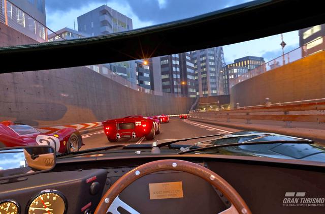 A driver's perspective from behind the wheel on a city highway with other race cars close by in this promo image for the video game 'Gran Turismo 7'.