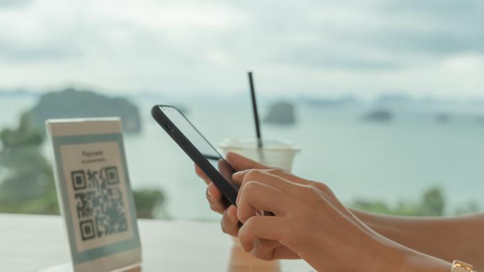 Woman use smartphone to scan QR code for order menu in cafe restaurant with a digital delivery. Choose menu and order accumulate discount. E wallet, technology, pay online, credit card, bank app.