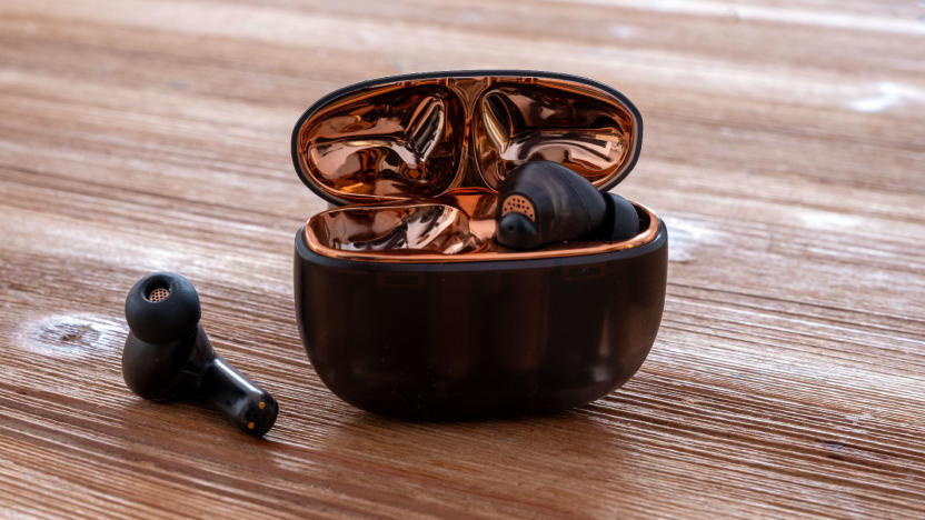 Creative's Aurvana Ace wireless headphones pictured on a table with the charging case open.