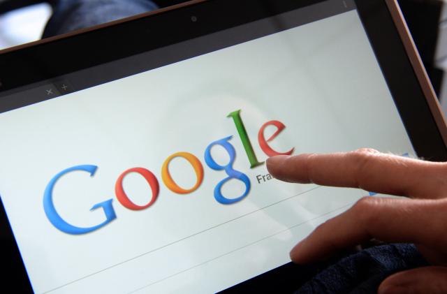 This picture taken on May 13, 2013 in the French western city of Rennes shows a woman choosing Google Search (or Google Web Search) web search engine front page on her tablet. A report by a French expert panel published on May 13, 2013 recommended imposing taxes on smartphones and tablets but rejected a call for search engine Google to be charged for linking to media content. The nine-member panel, headed by respected journalist and businessman Pierre Lescure, said in the keenly awaited report that the revenue gained from the proposed new taxes could help fund artistic and creative ventures. AFP PHOTO / DAMIEN MEYER        (Photo credit should read DAMIEN MEYER/AFP via Getty Images)