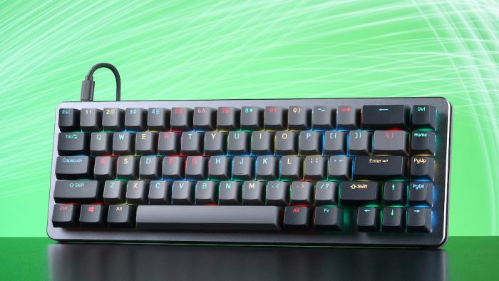 A colorful backlit black keyboard stands up against a green background. 