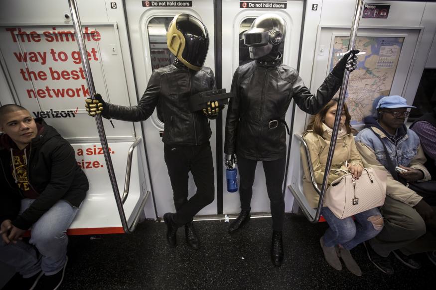 A couple dressed up as musical act Daft Punk ride the shuttle subway at Times Square station in the Manhattan borough of New York, October 31, 2015.   REUTERS/Carlo Allegri      TPX IMAGES OF THE DAY     