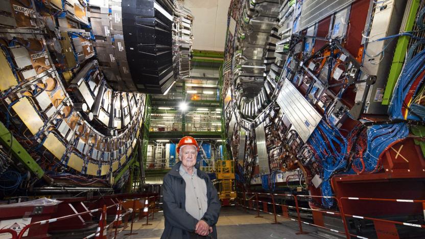 Peter Higgs standing in front of the Large Hadron collider.