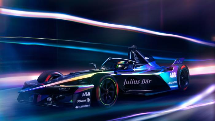 Formula E Gen3 Evo race car in motion with blurred lights all around it. 