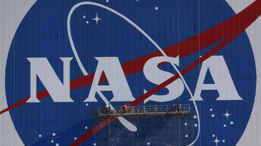 Painters refurbish the NASA logo on the Vehicle Assembly Building at the Kennedy Space Center in Florida in Florida on May 29, 2020. The faded 10-story-tall insignia was last painted 13 years ago. - The SpaceX Falcon 9 rocket with the Crew Dragon capsule is rescheduled to launch to the International Space Station on May 30, carrying astronauts Bob Behnken and Doug Hurley. (Photo by Gregg Newton / AFP) (Photo by GREGG NEWTON/AFP via Getty Images)