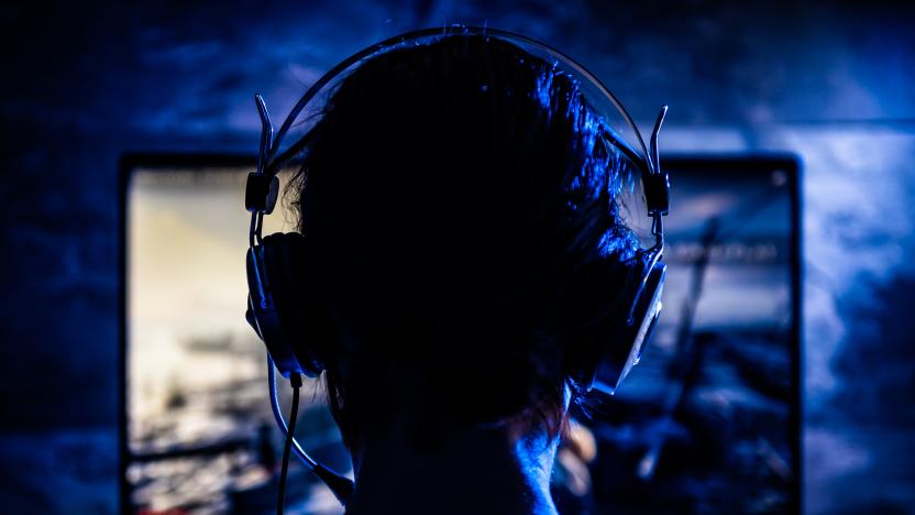 Woman wearing headphones playing video games late at night