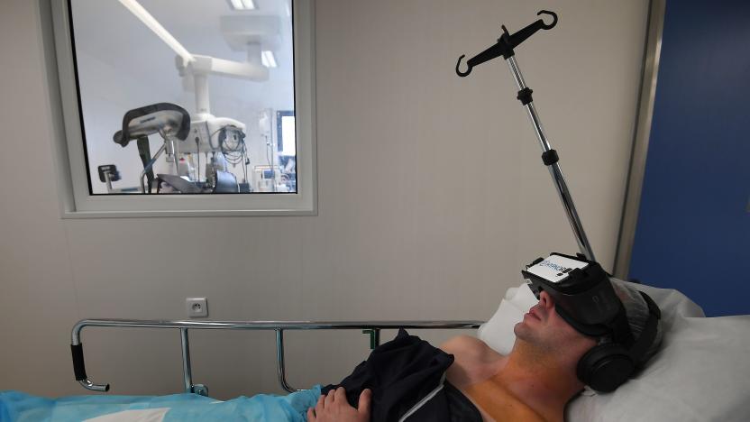 A patient wearing a virtual reality headset received a local anaesthesia by an hypnotherapist anaesthetist; before a surgery, at the Rhéna Clinic on October 25, 2018 in Strasbourg, eastern France. - HypnoVR, founded in 2016 by two anaesthetists and an entrepreneur, provides software and virtual reality headsets allowing the hypnotherapist to treat several patients. (Photo by Frederick FLORIN / AFP)        (Photo credit should read FREDERICK FLORIN/AFP via Getty Images)