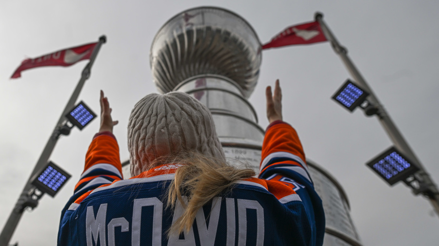 Getty Images - EDMONTON, CANADA - APRIL 21:
An Edmonton Oilers fan, wearing a Connor McDavid jersey with number 97, stands in front of the giant replica of the Stanley Cup on the eve of the Oilers' first Stanley Cup Playoff match against the Los Angeles Kings, on April 21 2024, in Edmonton, Alberta, Canada. (Photo by Artur Widak/NurPhoto via Getty Images)