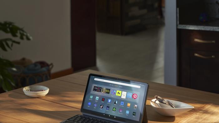 The Fire Max 11 tablet propped up by the kickstand on the back of its case, with a keyboard in front of the screen.