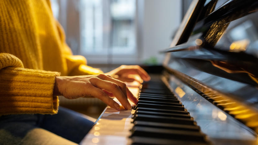 Close-up of female hands playing piano. Woman learning to play piano at home.