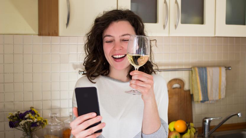 Happy young smiling caucasian woman making video call with smartphone at kitchen. Best friends drinking white wine and toasting. Video conference party online meeting with family. Stay home.Isolation