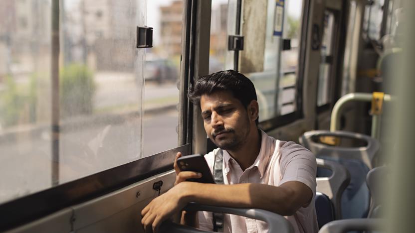 Young man using mobile phone while travelling in the bus