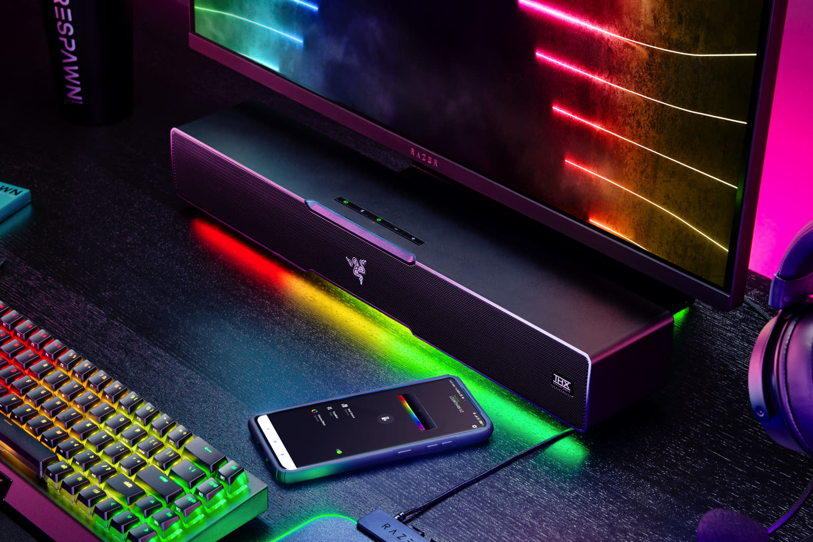 Razer Leviathan V2 on a table in a dark room, with a phone next to it