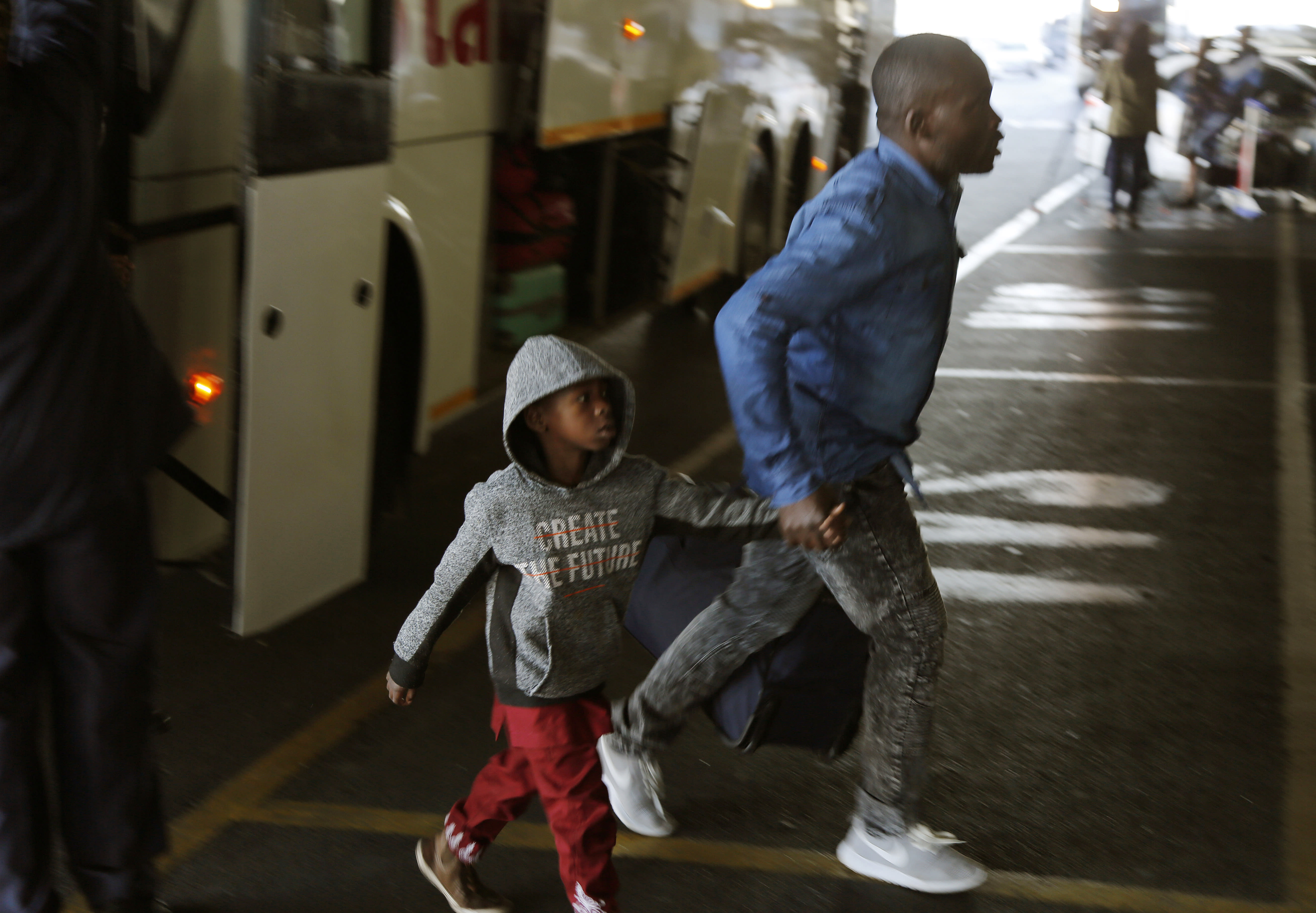 Nigerians exit a bus at the O.R. Tambo International Airport in Johannesburg, South Africa, Wednesday, Sept. 11, 2019. A group of Nigerians boarded a free flight from Johannesburg to Lagos on Wednesday, following a week of violence targeting foreigners in South Africa that has stoked tensions between Africa’s two largest economies. It was not immediately clear how many people were on board the flight, operated by the private Nigerian airline Air Peace, but Nigeria’s government said it estimated 313 people would board.(AP Photo/Denis Farrell)