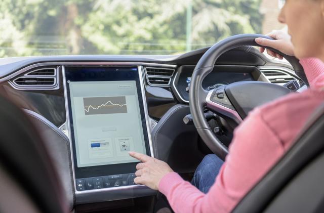 Woman using graphical display in electric car