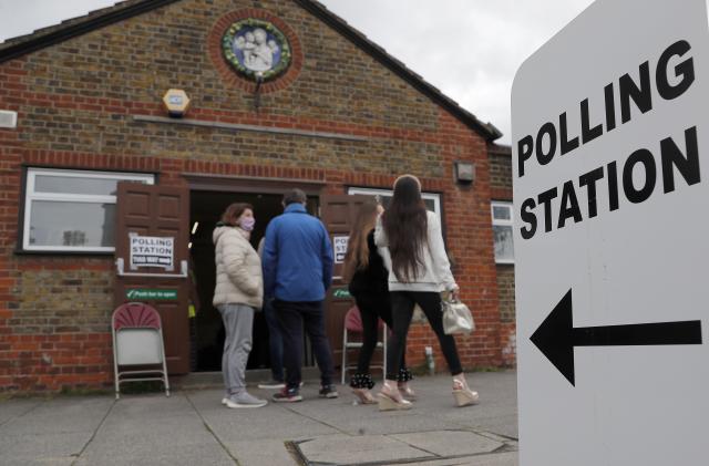 FILE - People queue at the entrance of a polling station in London, on May 6, 2021. Britain’s electoral watchdog said Friday, June 23, 2023 that about 14,000 people were prevented from voting in last month’s local elections because of a new law requiring voters to show photo identification. The Electoral Commission said 0.25% of people who went to polling stations were unable to cast ballots because they didn’t have the right ID, and “significantly more” than that likely did not show up at all. (AP Photo/Frank Augstein, File)