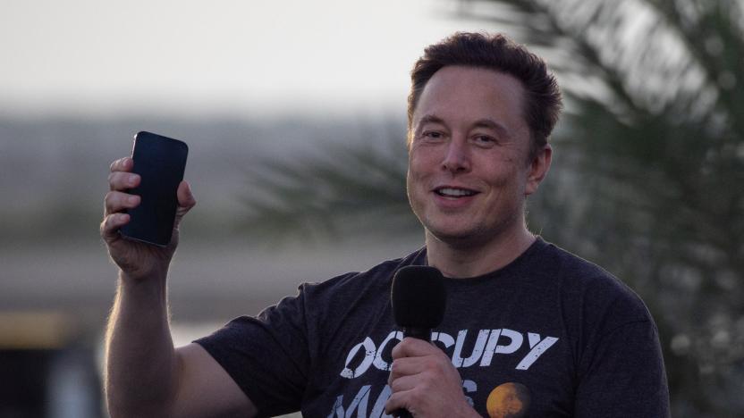 SpaceX Chief Engineer Elon Musk raises his phone during a joint news conference with T-Mobile CEO Mike Sievert at the SpaceX Starbase, in Brownsville, Texas, U.S., August 25, 2022. REUTERS/Adrees Latif